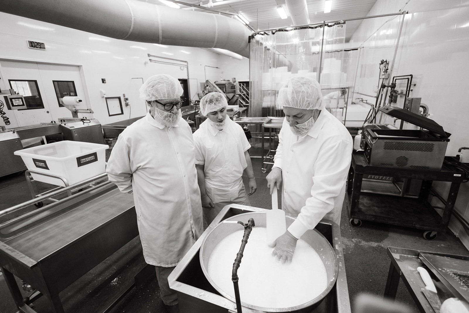 Cheesemakers working a vat of curd in the North Bennington creamery