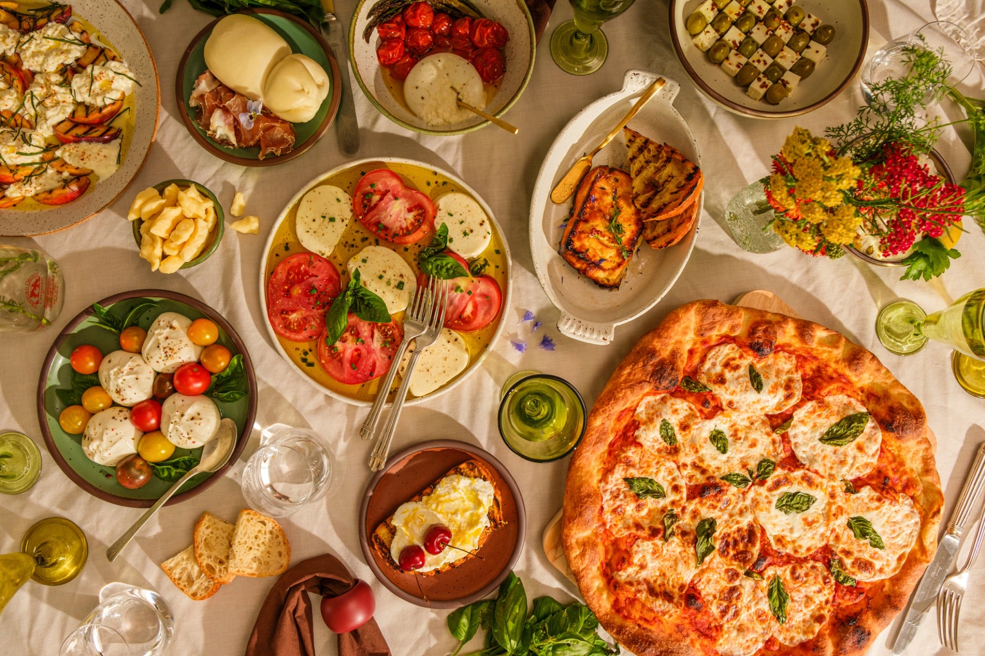 A table of Maplebrook cheeses, caprese, and pizza